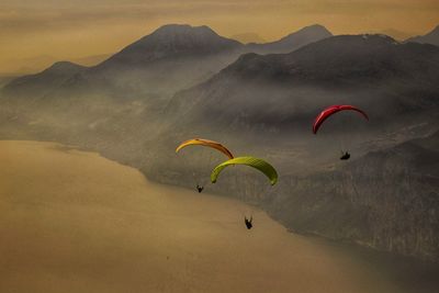 People paragliding over mountain against sky