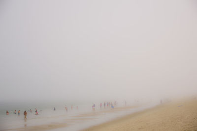 People on beach against sky