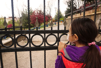 Rear view of woman standing by pink fence