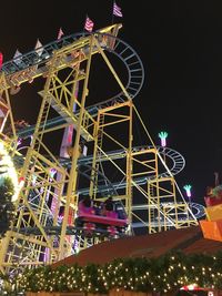 Low angle view of illuminated ferris wheel at night