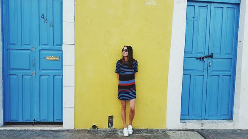 Woman standing against wall in city