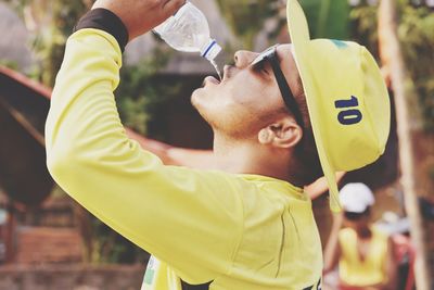 Side view of man drinking water outdoors