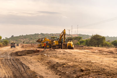 Excavator at construction site against sky