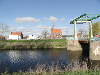 River by buildings against sky