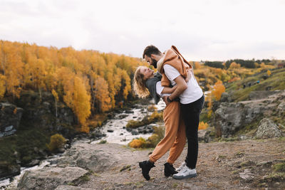 Happy people in love are travel hike in nature in the autumn forest. romantic trip to countryside