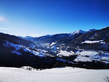 Scenic view of snowcapped mountains against clear blue sky