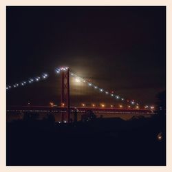 Illuminated suspension bridge at night