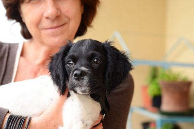 Close-up of woman with dog sitting at home