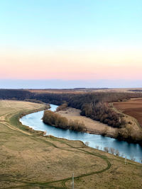 Scenic view of river against sky during sunset