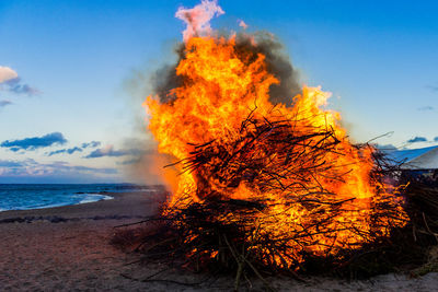 Bonfire on beach against sky