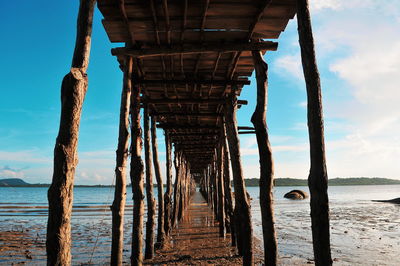 Wooden pier on sea against sky