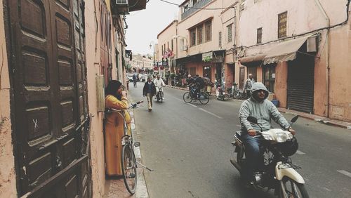 People riding bicycles on road in city