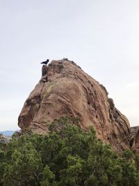 Low angle view of cliff on mountain against clear sky