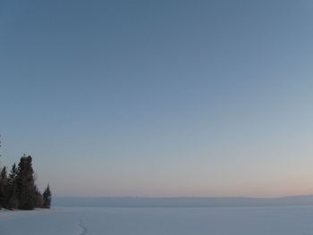 Scenic view of snow against clear blue sky during winter