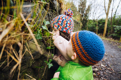 A young brother and sister looking for creatures on a nature walk