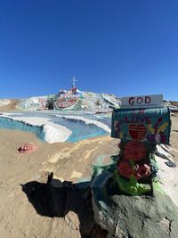 Scenic view of beach against clear blue sky