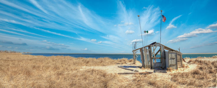 Fluffy clouds and blue sky over the occupy chatham public shack on chatham south beach on cape cod.