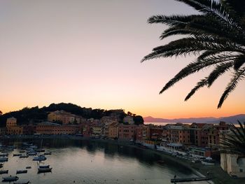 Canal amidst buildings against sky during sunset