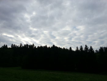 Silhouette of trees on field against sky