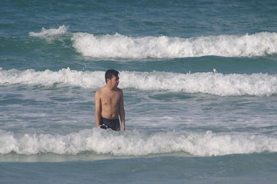 Full length of shirtless man in sea