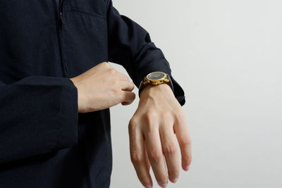 Midsection of man holding hands over white background