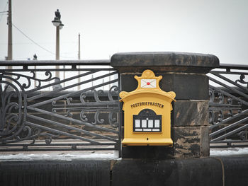 Mailbox on footbridge against clear sky