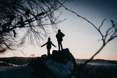 Low angle view of silhouette boy against sky