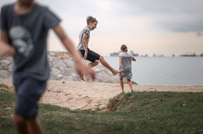 Rear view of men running on beach