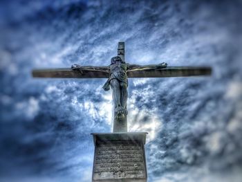 Low angle view of cross statue against sky