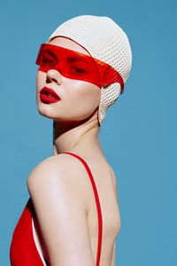 Low angle view of woman wearing hat against blue background