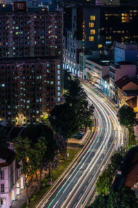 High angle view of light trails on street amidst buildings at night