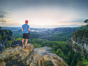 Rear view of man looking at mountains against sky