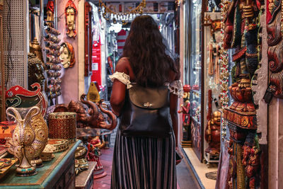 Rear view of woman standing at antique store