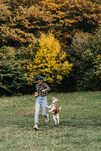 Rear view of woman with dog on field