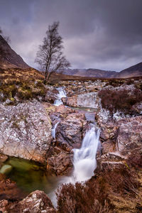 Scenic view of waterfall against sky