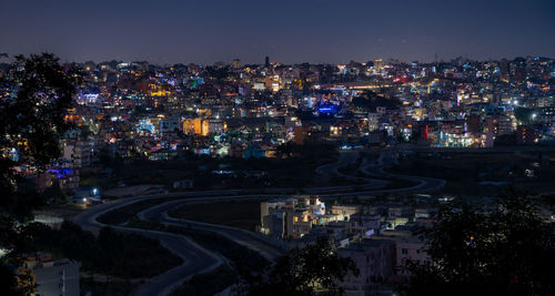 High angle view of illuminated cityscape against sky at night