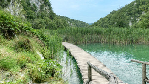 Scenic view of plitvice lake by trees against sky