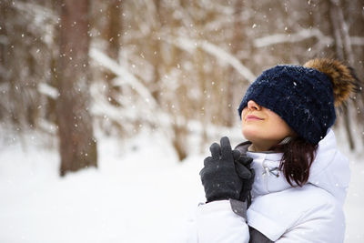 Close-up of woman standing on snow covered field