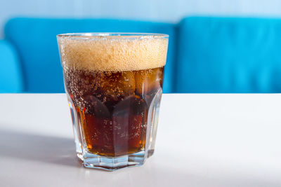 A glass of cola with ice on the table. cold refreshing drink