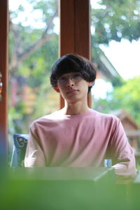 Portrait of boy looking through window