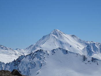 Scenic view of snowcapped mountains against clear blue sky