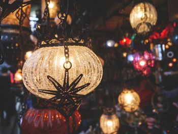 Illuminated christmas lanterns hanging for sale in store at night