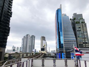 Modern buildings in city against cloudy sky