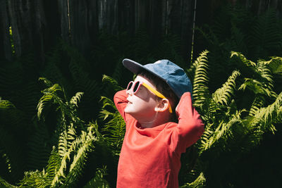 Happy child looking up at the sun in sunglasses. the concept of  self-care and simple pleasures. 