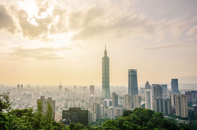 Buildings in city against cloudy sky