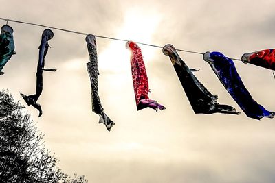 Low angle view of hanging flags against sky