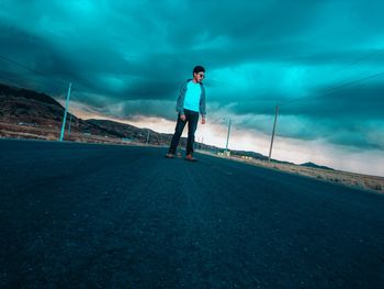 Man standing on road against sky