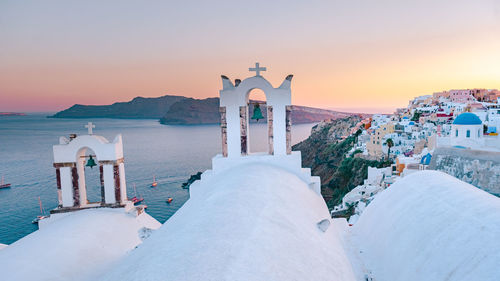 Panoramic view of sea and buildings against sky during sunset