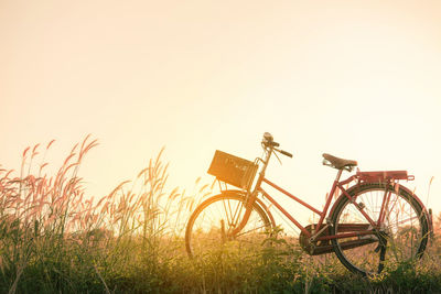 Bicycle on field against clear sky