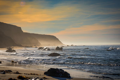 Scenic view of beach against sky during sunset